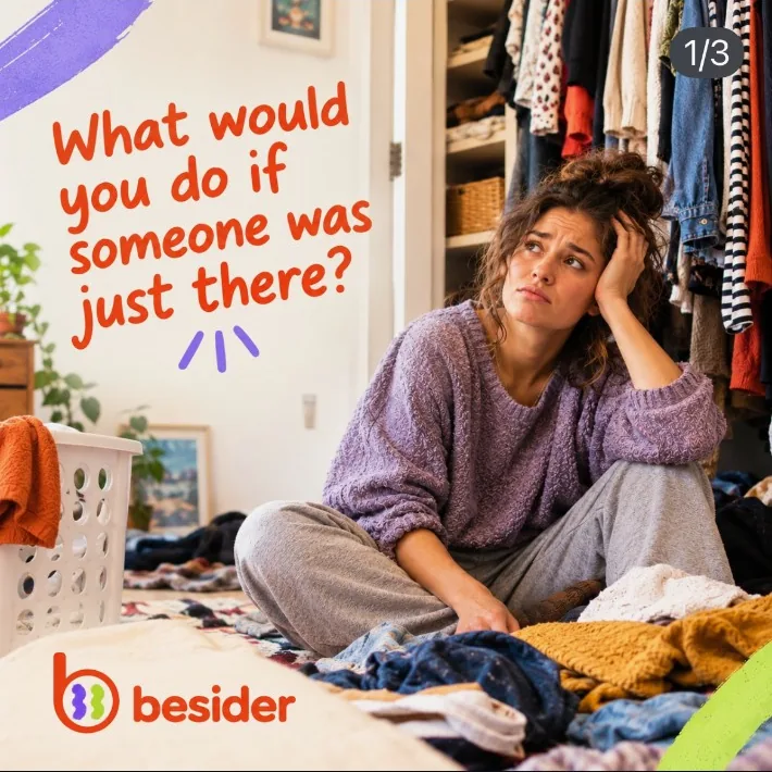 A woman sitting amid laundry, feeling stuck